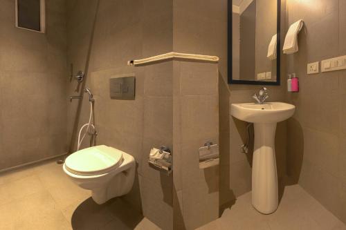 a bathroom with a toilet and a sink at Hotel GT at Delhi Airport in New Delhi