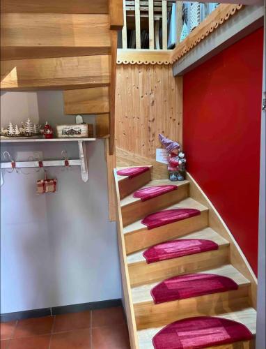 un escalier en colimaçon dans une cuisine avec des coussins roses dans l'établissement Chalet duplex avec terrasse entièrement équipé60m2, à Gérardmer