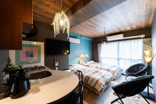 Habitación con 2 camas y cocina con fregadero. en Few Days Condominium 205, en Jozankei