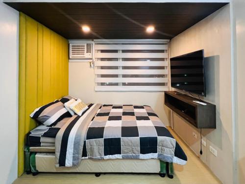 a small bedroom with a bed and a television at * *R Metropolitan Mirage in Iloilo City