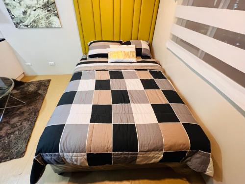 a bedroom with a bed with a checkered blanket at * *R Metropolitan Mirage in Iloilo City