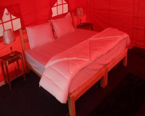 a red bed in a room with a red tent at StayApart at Alpine Ibex Camp, Nubra Valley in Leh