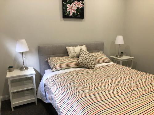 a bedroom with a bed with two night stands and two lamps at Beaufort House in Port Noarlunga