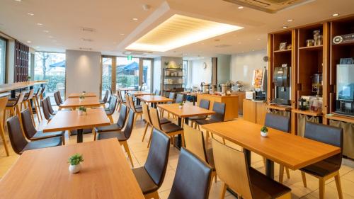 a restaurant with wooden tables and chairs at Meitetsu Inn Nagoya Kanayama in Nagoya