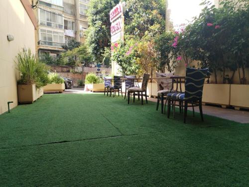 un groupe de chaises assises sur une pelouse verte dans l'établissement Bella Rosa Hotel, à Beyrouth