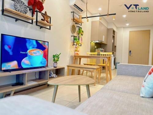 a living room with a flat screen tv on a wall at The Song Vung Tau Homestay - VTLand in Vung Tau