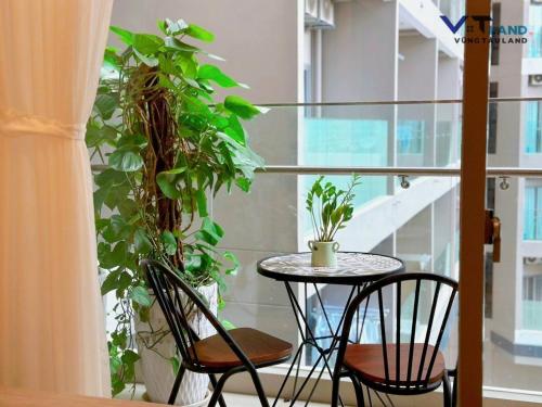 a balcony with a table and chairs and plants at The Song Vung Tau Homestay - VTLand in Vung Tau