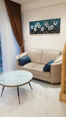 - un salon avec un canapé et une table dans l'établissement Apartemen Grand Jati Junction, à Medan