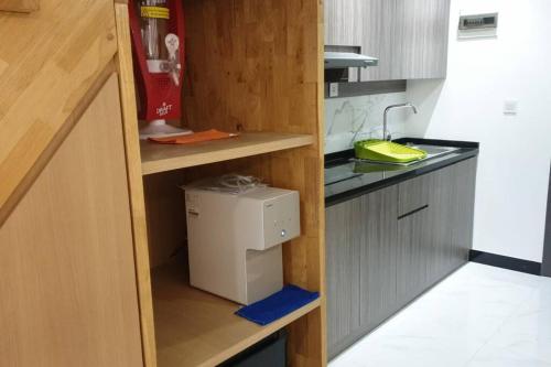 Il comprend une cuisine équipée d'un évier et d'un comptoir avec un four micro-ondes. dans l'établissement Apartemen Grand Jati Junction, à Medan