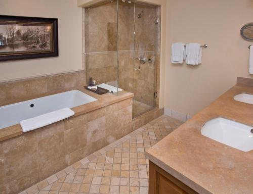 a bathroom with two sinks and a tub and a shower at The Arrabelle at Vail Square, a RockResort in Vail