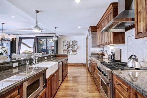 a kitchen with wooden cabinets and stainless steel appliances at The Arrabelle at Vail Square, a RockResort in Vail
