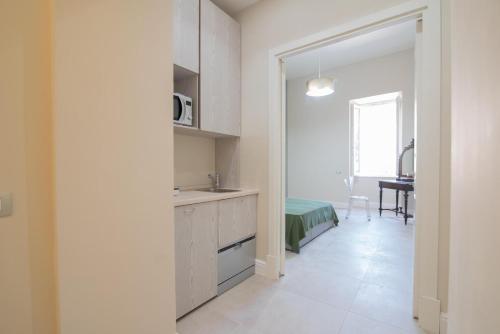 eine Küche mit weißen Schränken und einem Tisch im Zimmer in der Unterkunft La Finestra Sul Vulcano in Roccamonfina