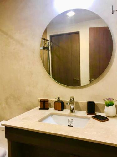 a bathroom with a sink and a mirror at ☆ Location & Comfort ☆ Jacuzzi ☆ Luxury Condo in Tulum