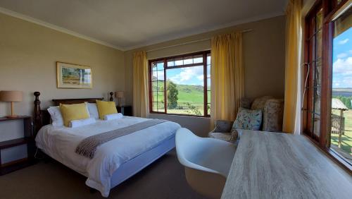 a bedroom with a large bed and a large window at Berryfields in Dullstroom