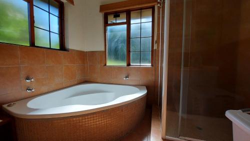 a large bath tub in a bathroom with a window at Berryfields in Dullstroom