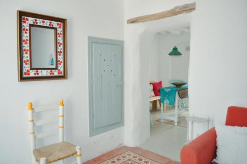 a living room with a mirror and a table at Casa Mosaico Granada en el V de Lecrin in Nigüelas