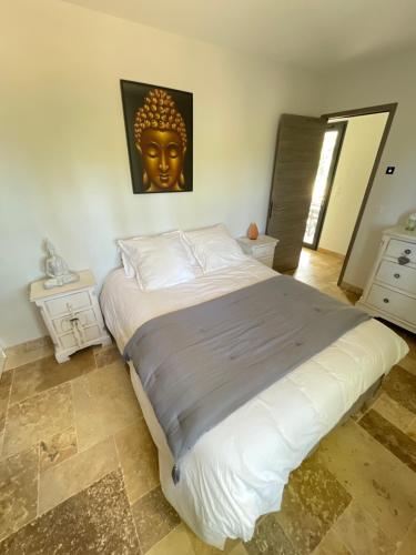 um quarto com uma cama grande e uma cabeça dourada na parede em Chambre d hôtes LA MANDALA em Plan dʼAups