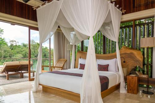 Postel nebo postele na pokoji v ubytování Komaneka at Tanggayuda Ubud