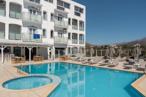 a hotel with a swimming pool in front of a building at Areti Hotel in Agia Galini