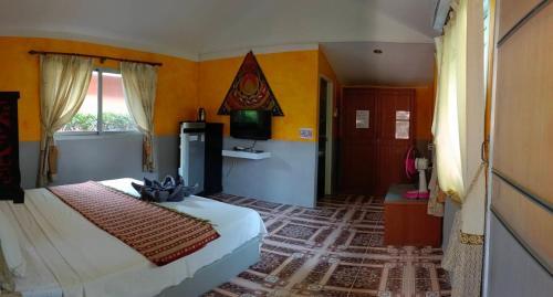 - une chambre avec un lit et une télévision dans l'établissement Ban Elephant Blanc Bungalow, à Kata Beach