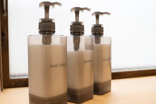 three bottles of milk sitting on a table at つばめ荘 Tsubamesou 尾道駅から徒歩と渡船で15分 情緒あふれる尾道ステイ 鍵付き駐輪場と駐車場あり supported by COCOSTAY in Onomichi