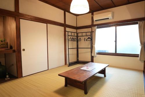 salon ze stołem i dużym oknem w obiekcie つばめ荘 Tsubamesou w mieście Onomichi