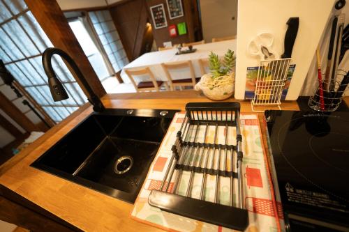 a kitchen with a sink and a counter top with dishes at つばめ荘 Tsubamesou 尾道駅から徒歩と渡船で15分 情緒あふれる尾道ステイ 鍵付き駐輪場と駐車場あり supported by COCOSTAY in Onomichi