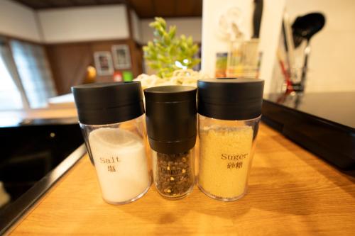 three containers of spices sitting on top of a counter at つばめ荘 Tsubamesou 尾道駅から徒歩と渡船で15分 情緒あふれる尾道ステイ 鍵付き駐輪場と駐車場あり supported by COCOSTAY in Onomichi