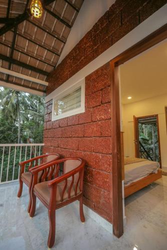 a brick wall with two benches on a balcony at Redstone Villa in Tāzhekkod