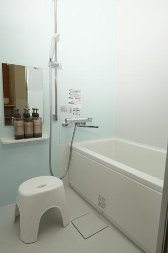 a white bathroom with a toilet and a shower at つばめ荘 Tsubamesou 尾道駅から徒歩と渡船で15分 情緒あふれる尾道ステイ 鍵付き駐輪場と駐車場あり supported by COCOSTAY in Onomichi