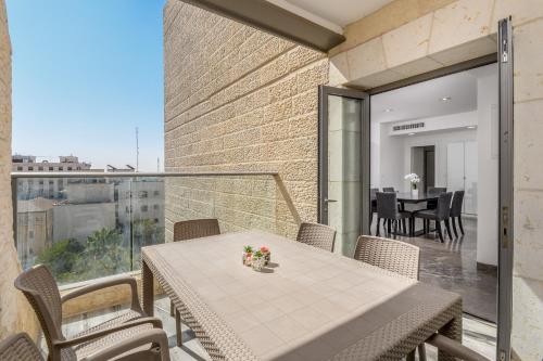 d'une salle à manger avec une table et des chaises sur un balcon. dans l'établissement Luxury 3BR - Rav Kook - Floor 7, à Jérusalem