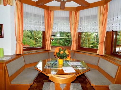 a dining room with a table and two windows at Gästehaus Summer in Schruns-Tschagguns