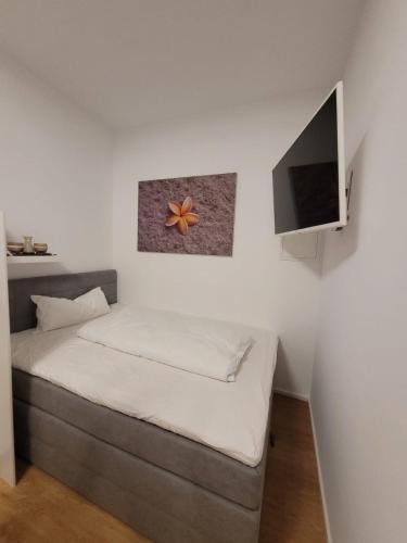 a bedroom with a bed and a flat screen tv at Apartments an der Bühleiche in Plochingen