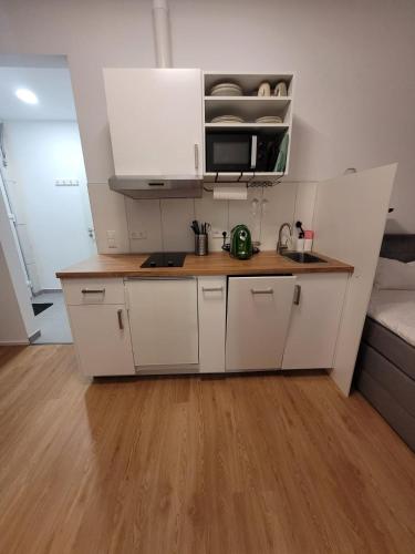 cocina con armarios blancos y suelo de madera en Apartments an der Bühleiche, en Plochingen