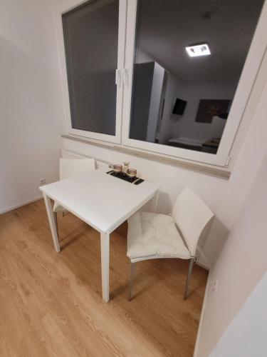 een witte tafel en stoel in een kamer met een spiegel bij Apartments an der Bühleiche in Plochingen