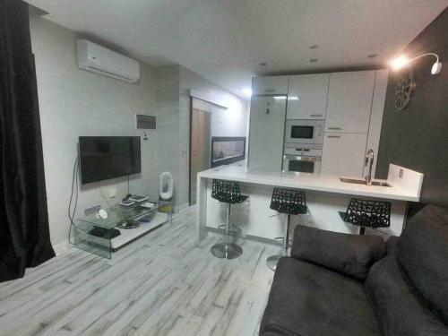 salon z kanapą i kuchnią w obiekcie Apartamento con diseño moderno y piscina Taurito w mieście Taurito