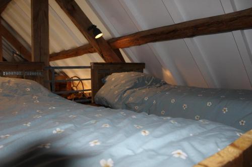 two beds in a room with a roof at De hooizolder Hofstay195 in Achterveld