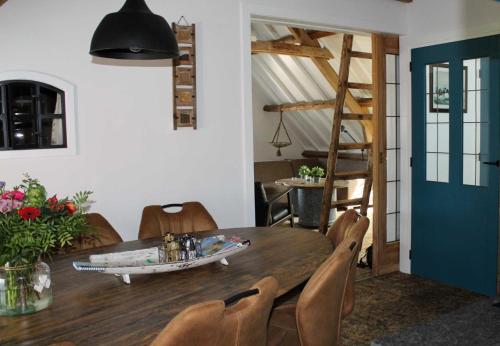 Achterveld的住宿－De hooizolder Hofstay195，一间设有桌子的用餐室,上面有一条船