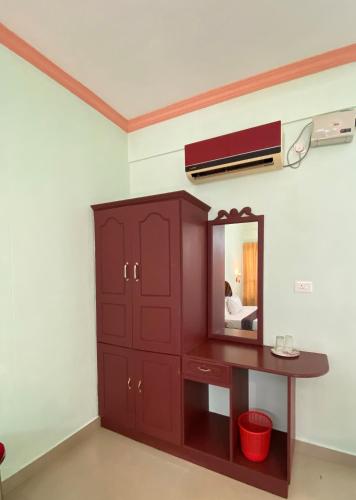 a bedroom with a dresser and a mirror at Packbag Comfort Bed & Breakfast in Kovalam