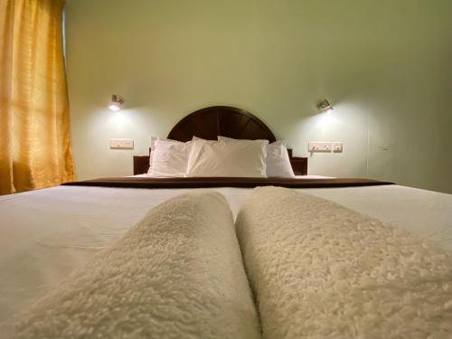 a bedroom with a bed with two towels on it at Packbag Comfort Bed & Breakfast in Kovalam