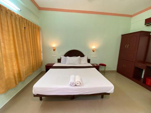 a bedroom with a bed with two towels on it at Packbag Comfort Bed & Breakfast in Kovalam