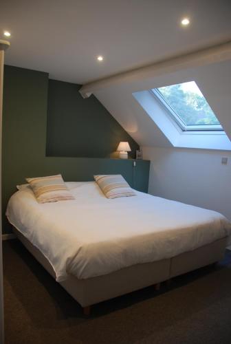 sypialnia z dużym łóżkiem i oknem w obiekcie The Little House w mieście Beersel