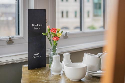 a table with a vase of flowers and a box at The Riverside in Kendal