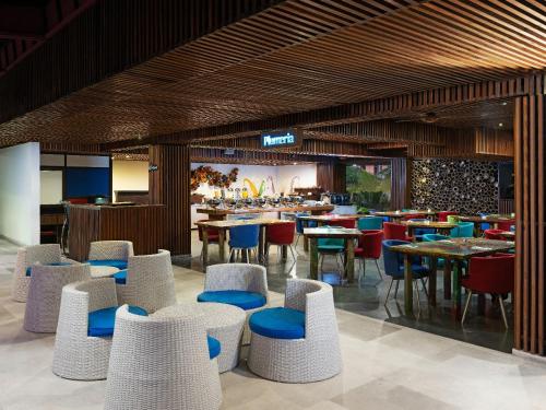 a restaurant with chairs and tables and a bar at The Bene Hotel in Kuta