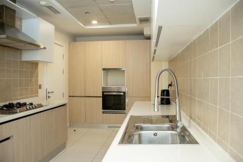 a kitchen with a sink and a stove at Centaurus Hotel Suites in Islamabad