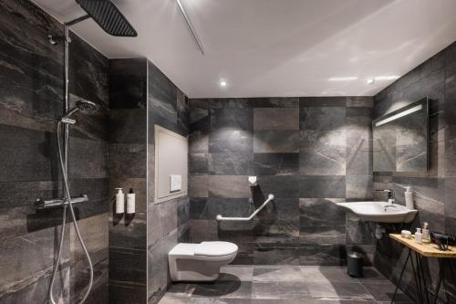 y baño con ducha, aseo y lavamanos. en Hôtel Ski Lodge - Village Montana en Val dʼIsère