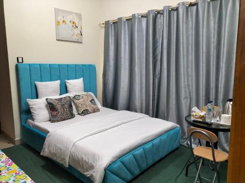 a bed with a blue headboard in a room at GRACE BEDSPACE, HOSTEL AND ACCOMODATIONS in Dubai