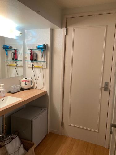 a bathroom with a white door and a sink at Town Hotel 41 in Kanazawa