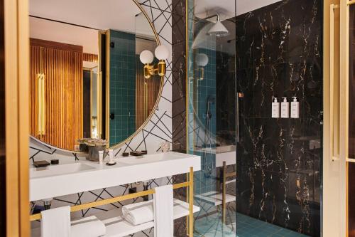 La salle de bains est pourvue d'un lavabo et d'un miroir. dans l'établissement Grand Hyatt Barcelona, à Barcelone
