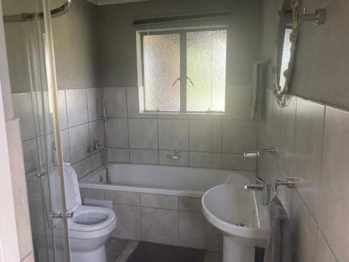 a bathroom with a tub and a toilet and a sink at Mountain View Farm Cottage 4X4 Vehicles ONLY in Dullstroom